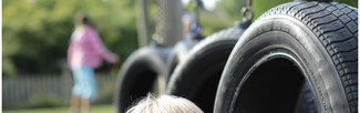 Boy poking his head through a tyre on the obstacle course