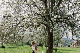 A woman walks a dog across a field