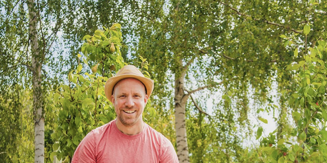 Author Joe Emmet in a garden with his dog