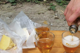 glasses of cider and a wedge of cheese