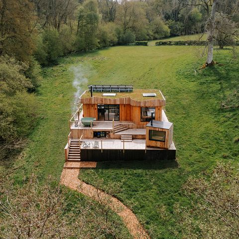 scandi cabin set in amongst fields and woodland
